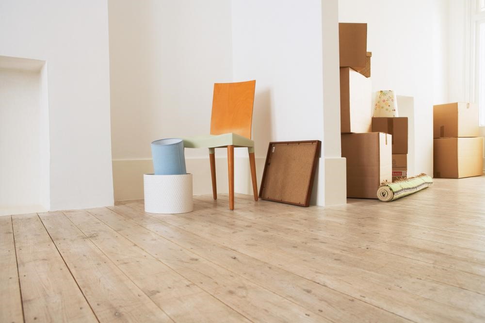 Stack of boxes and a chair on wood flooring