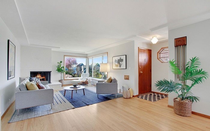 A fully furnished living room with custom hardwood floors.