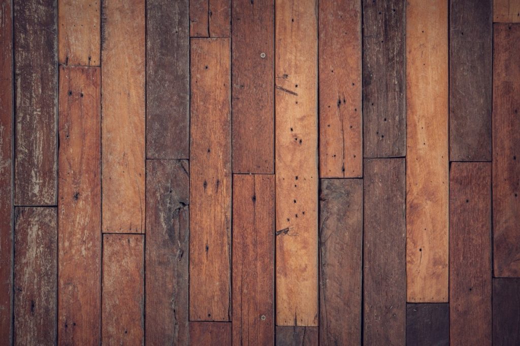 A hardwood floor inside a home that has begun to crack.
