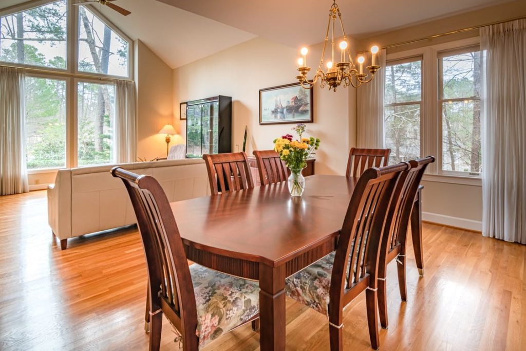 A wooden dining table and chairs with a hardwood floor.