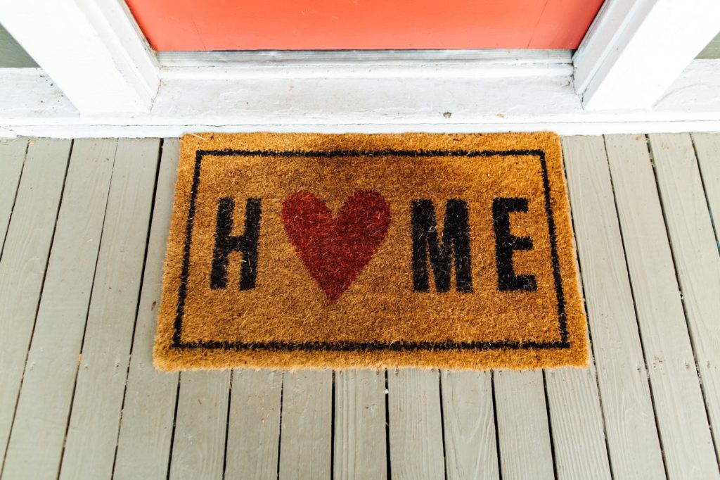A rug outside a home with hardwood flooring