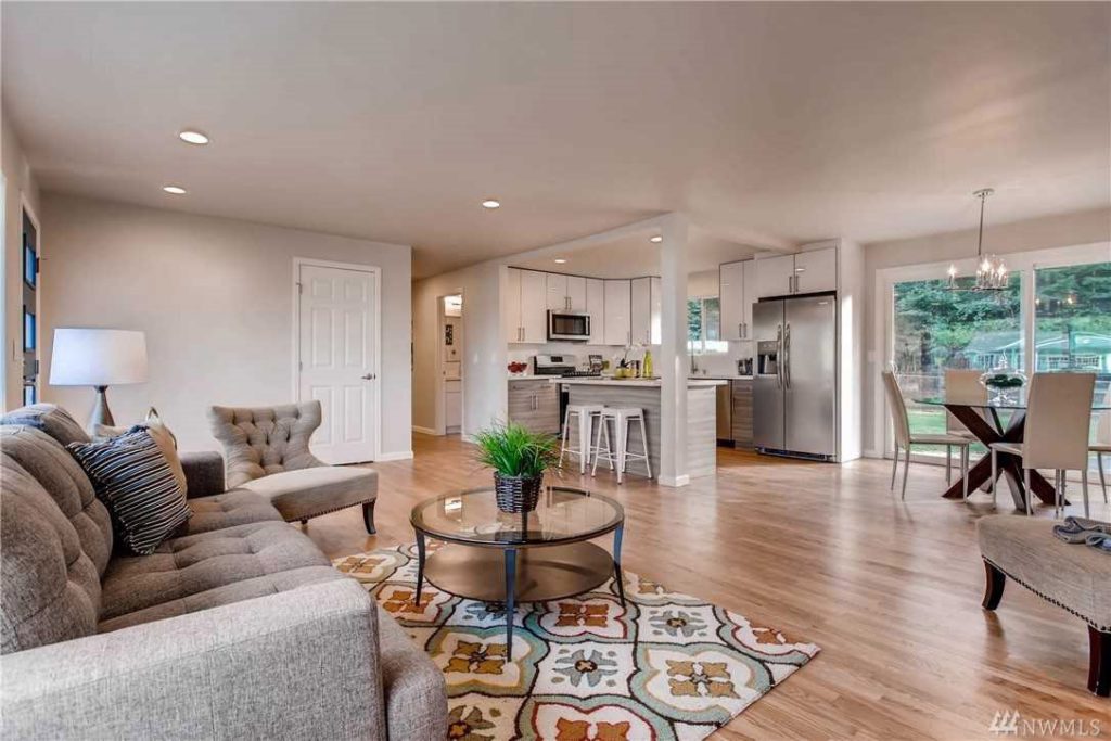 A living room with horizontal hardwood flooring by Five Star Hardwood