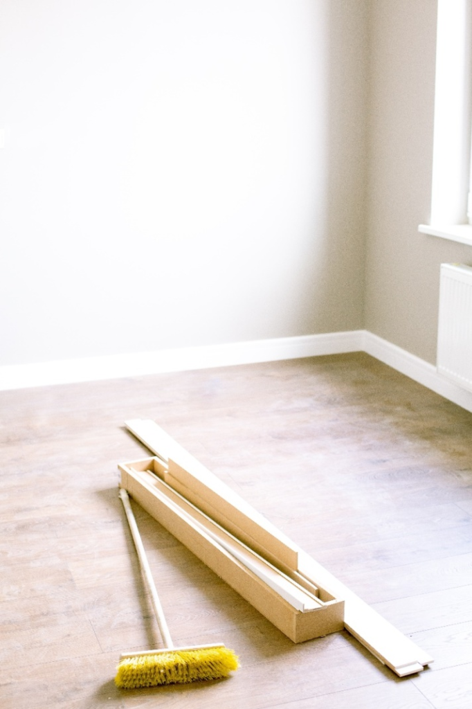 Brush and wooden planks on hardwood floor.