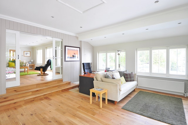 A white couch and black mat on a wooden floor