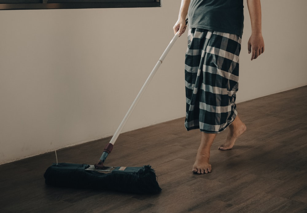 A man mopping hardwood floor