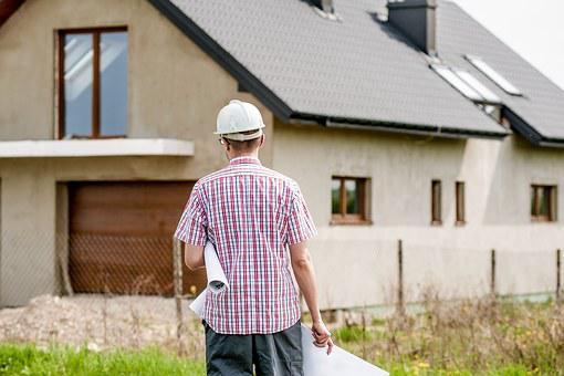 A flooring contractor walking towards a house