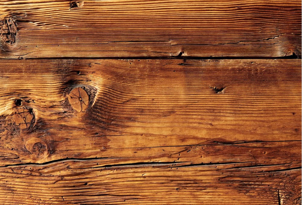 Solid hardwood plank with several dents and scratches