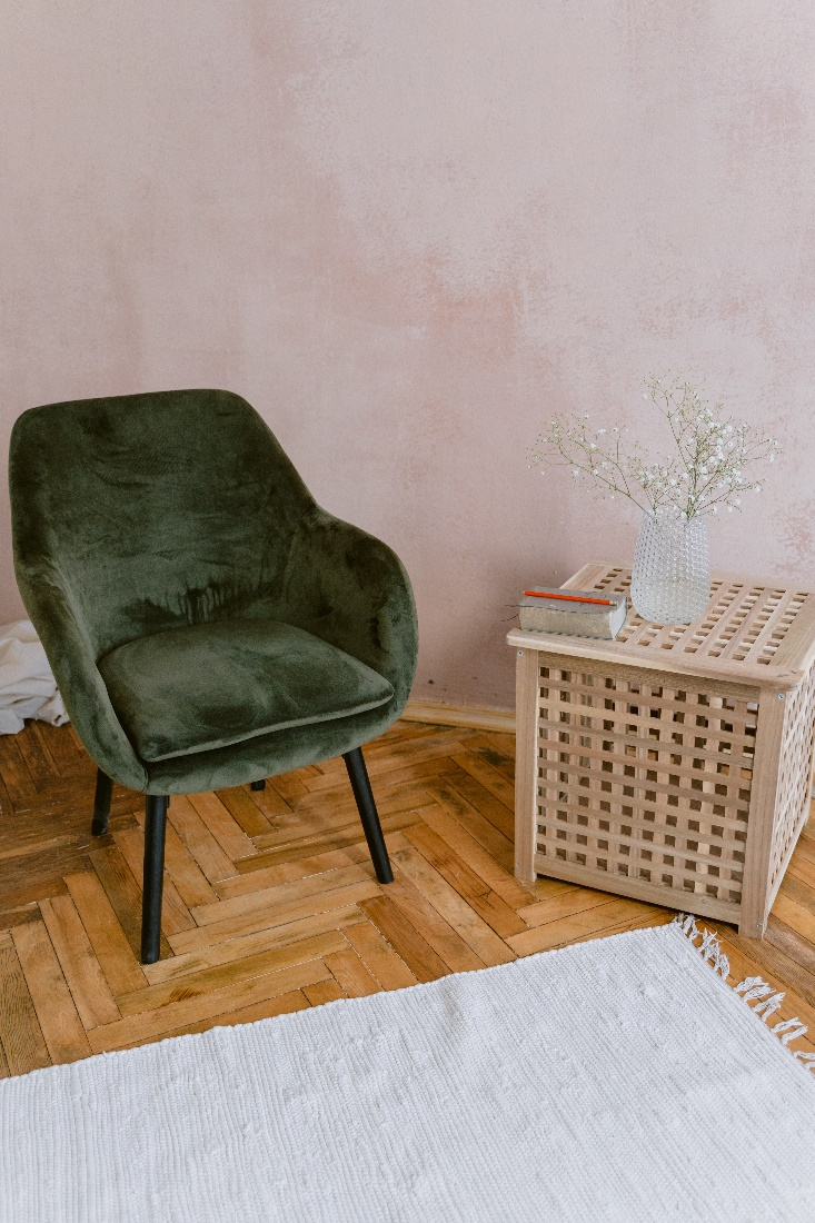 A green chair beside a brown wooden table