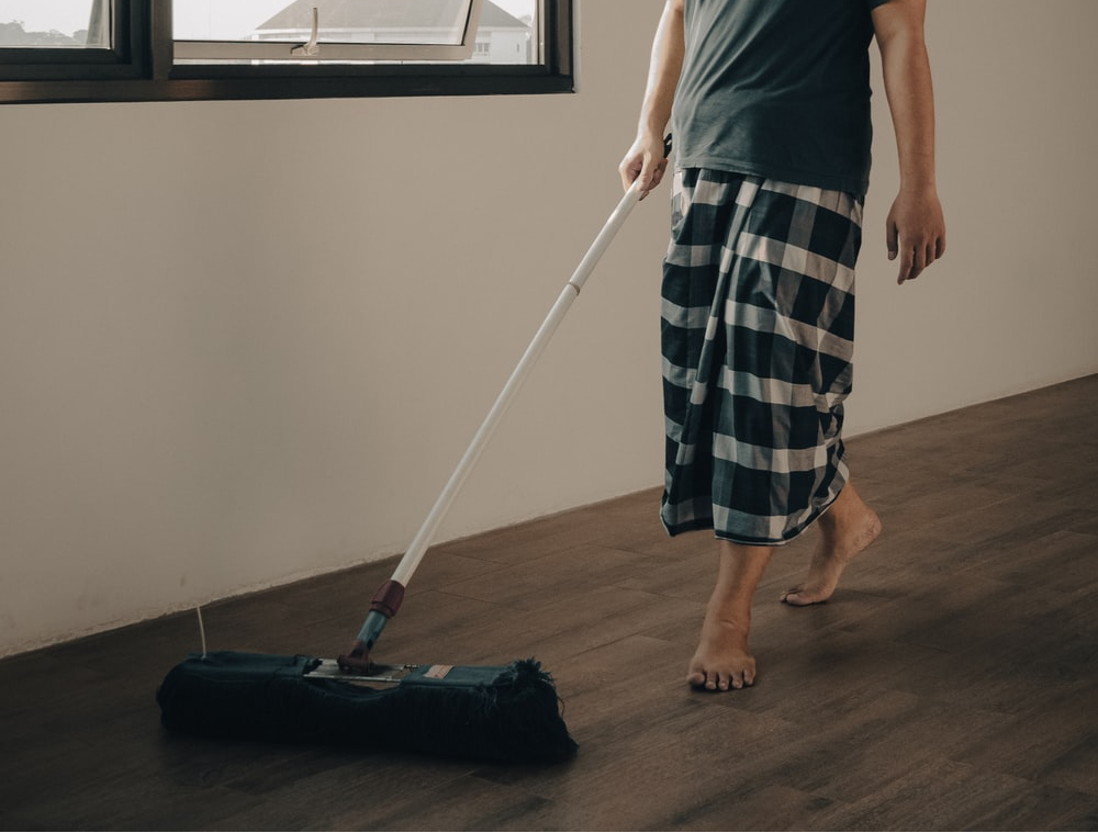 A man sweeping hardwood floor