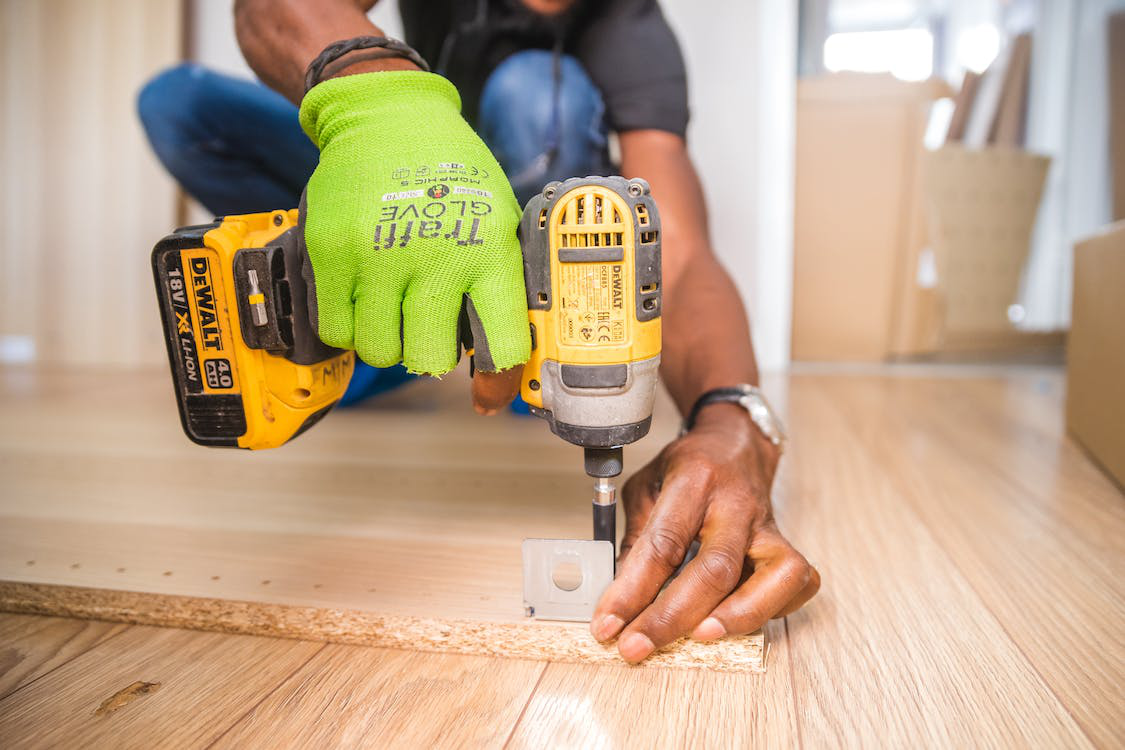 A person installing a wooden floor in a house