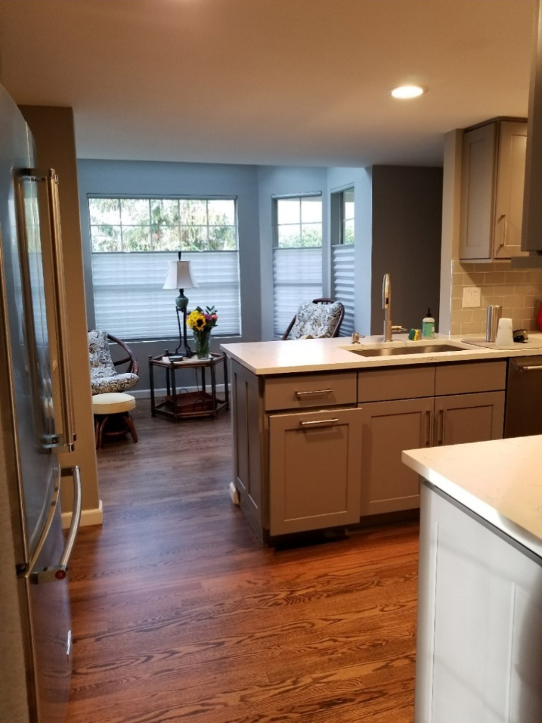 A kitchen area with a hardwood floor