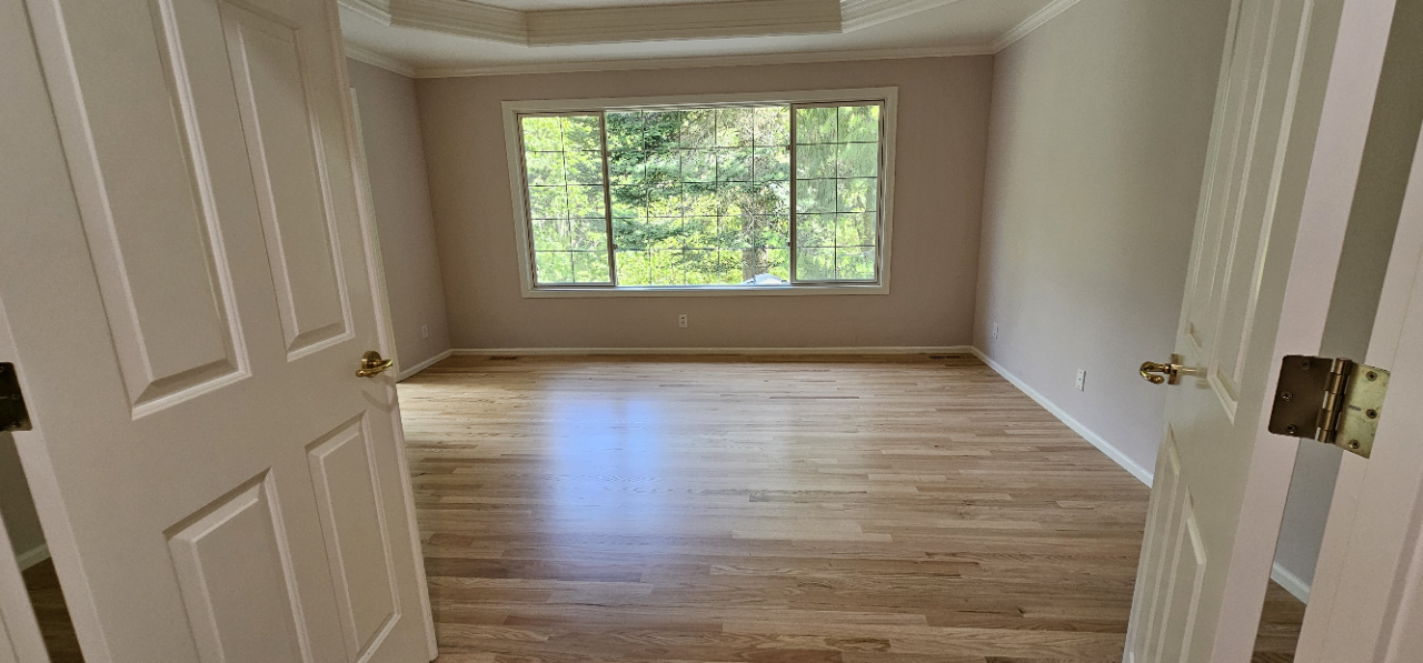 An empty room with a hardwood floor