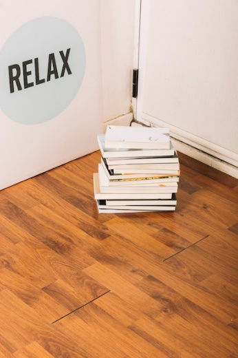 A picture of a stack of book lying on a wooden floor