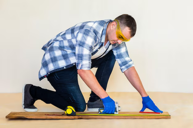 Flooring expert taking precise measurements for replacing old wood floors with new quality hardwood.