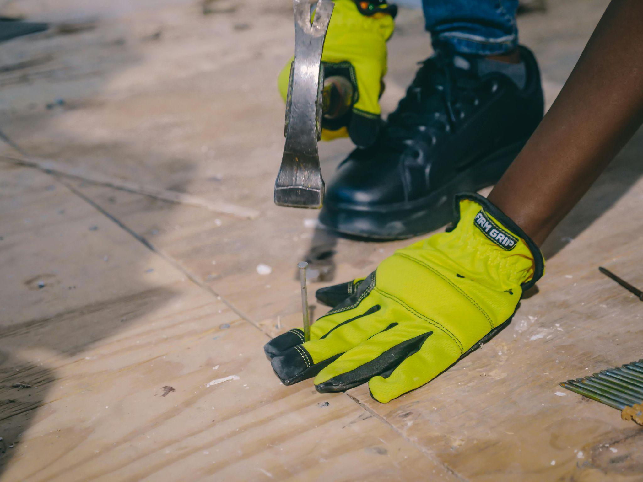 A worker hammering on a wooden floor