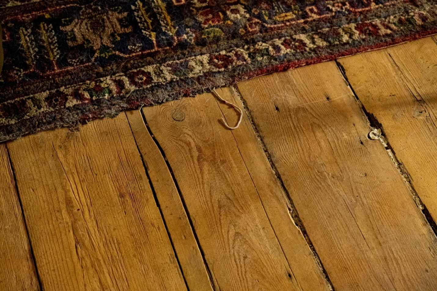 A hardwood floor can be seen with a carpet